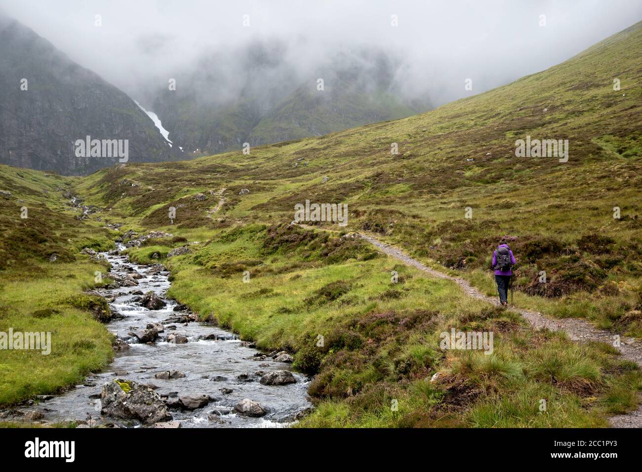 Walker auf dem Weg nach Coire Ardair im Creag Meagaidh Nature Reserve an einem feuchten Summers Tag. Stockfoto