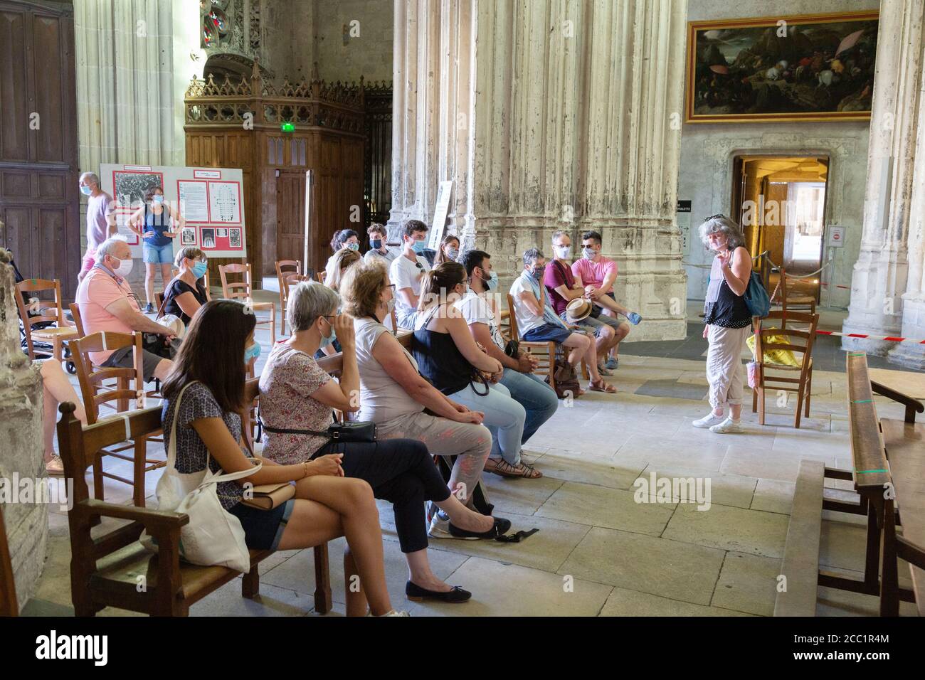 Covid 19 Tourismus und Reisen; eine geführte Tour für Touristen, Tours Kathedrale, Frankreich, Tour Guide und Touristengruppe soziale Distanzierung und alle tragen Masken Stockfoto