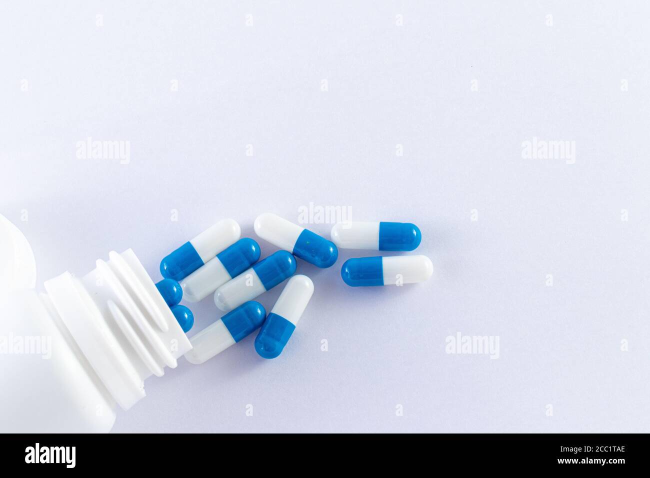 Medicine Tabletten innen und außen eine weiße Plastikflasche auf weißem Hintergrund. Stockfoto