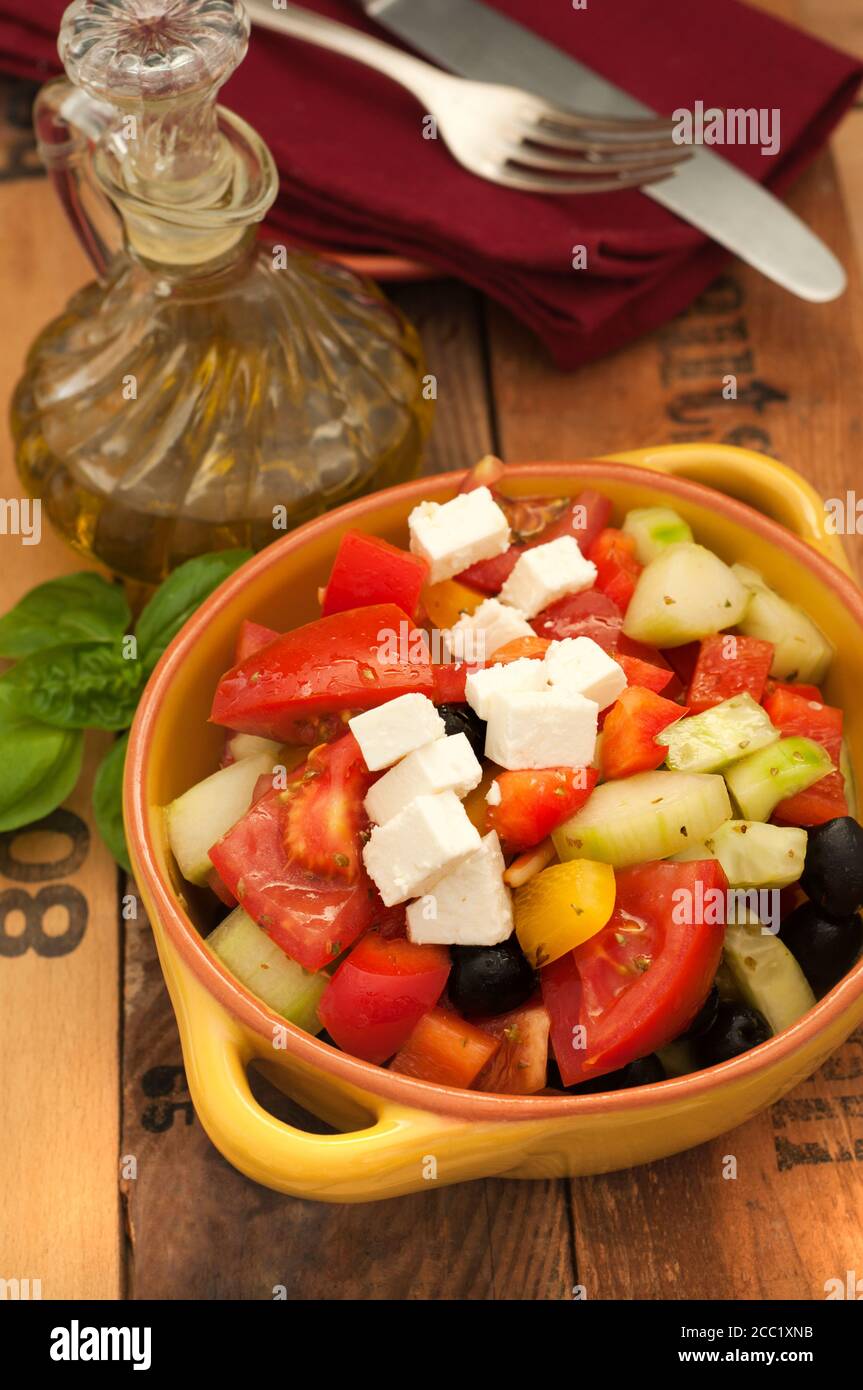 Schüssel griechischen Salat mit Feta-Käse und schwarzen Oliven auf Holztisch, Nahaufnahme Stockfoto