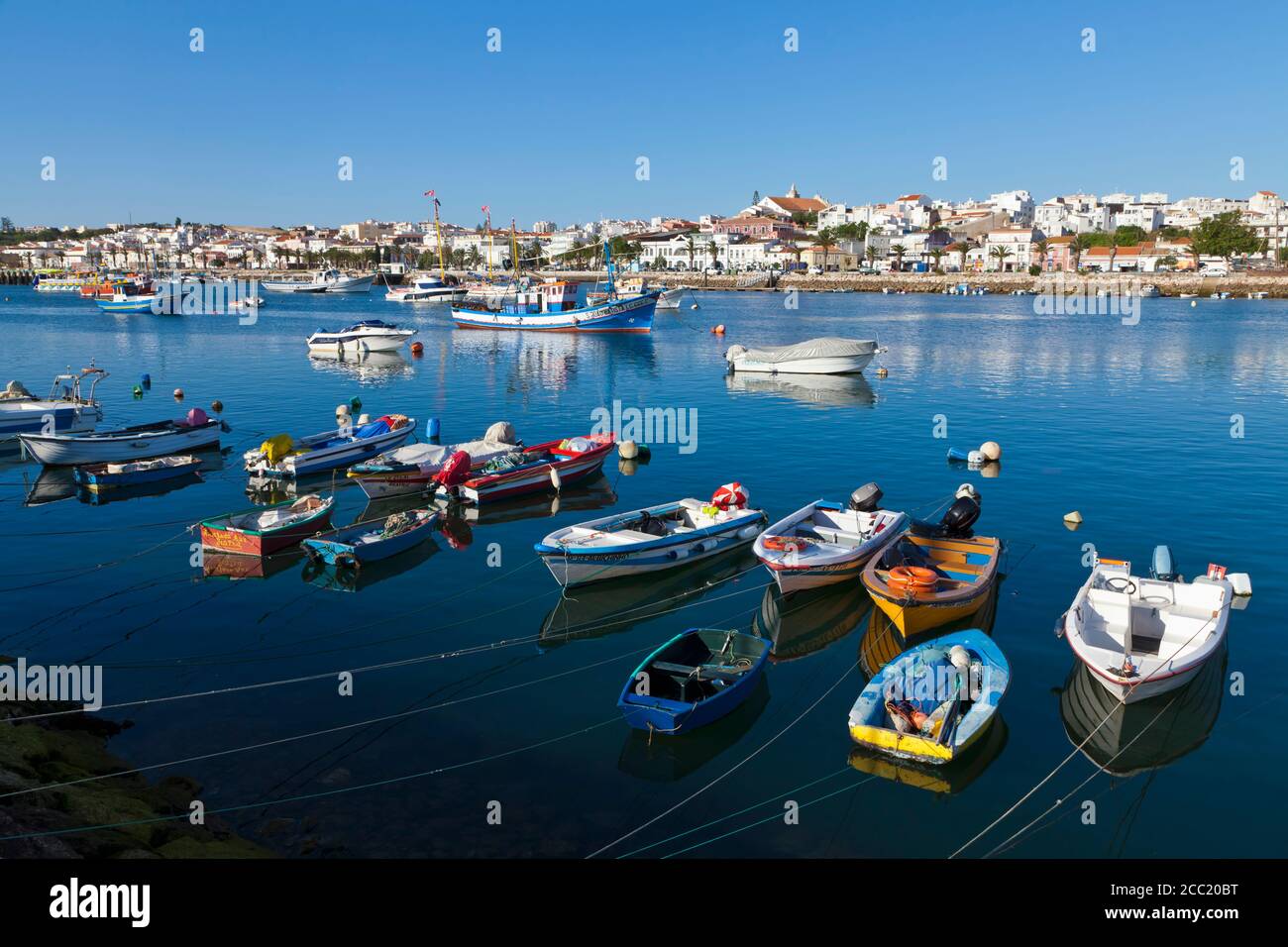 Portugal, Lagos, Blick auf die Fischerboote im Hafen und Stadt im Hintergrund Stockfoto