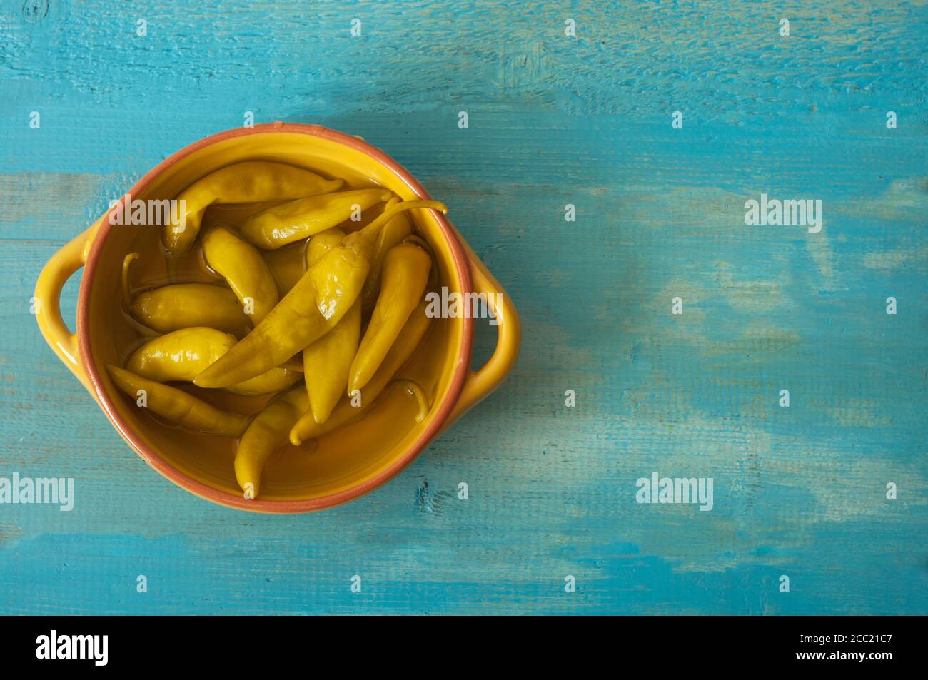 Schüssel von Chilischoten auf Holztisch, Nahaufnahme Stockfoto