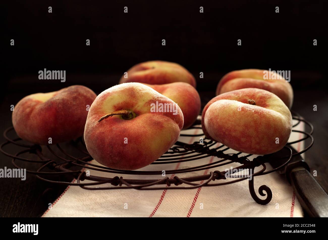 Pfirsiche mit Messer auf Kuchengitter, Nahaufnahme Stockfoto