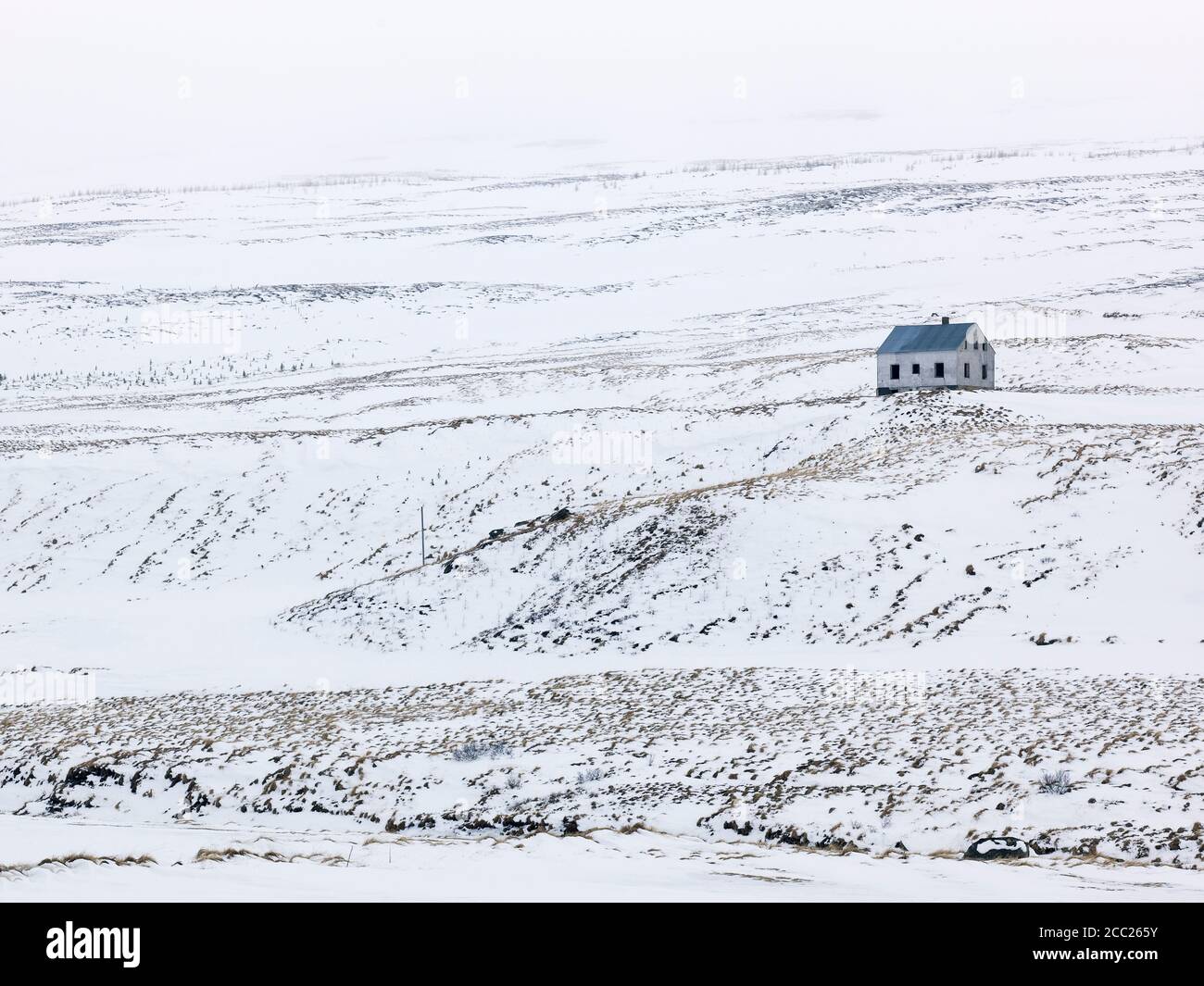 Island, Blick auf einsamen Haus in winterlicher Landschaft Stockfoto