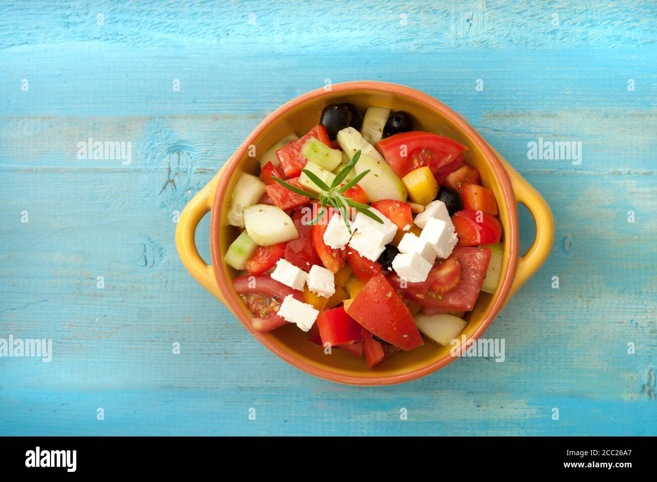 Schüssel griechischen Salat mit Feta-Käse und schwarzen Oliven auf Holztisch, Nahaufnahme Stockfoto