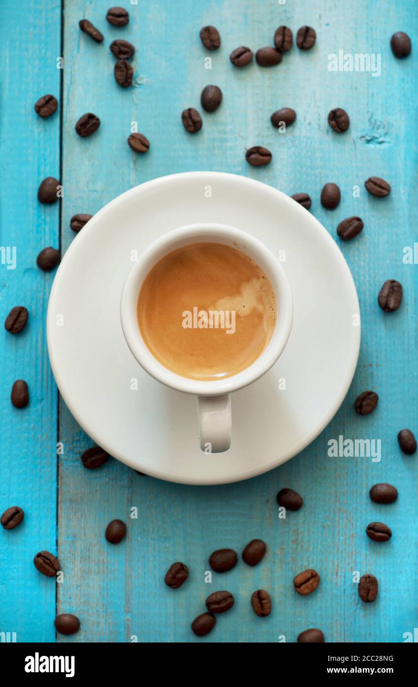 Espresso mit Kaffeebohnen auf Holztisch, Nahaufnahme Stockfoto