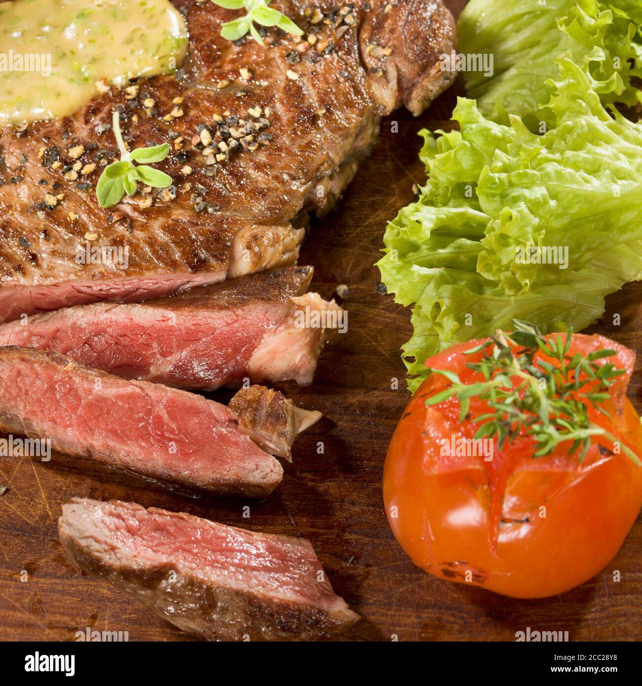 Gegrillte Rib-Eye Steak mit Kräutersauce auf Holz Stockfoto