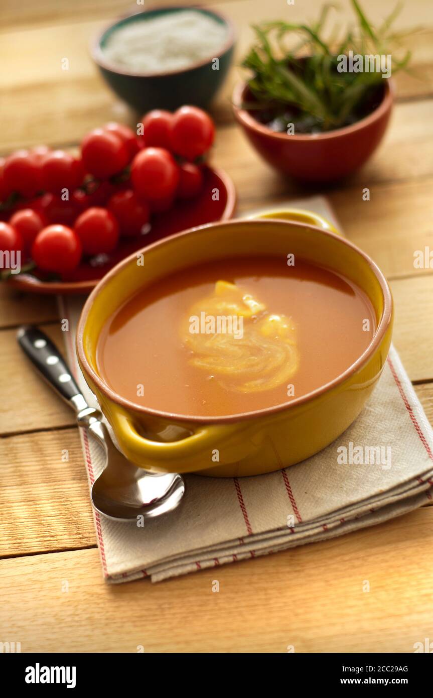 Schüssel Tomatensuppe und Kirschtomaten auf Holztisch, Nahaufnahme Stockfoto