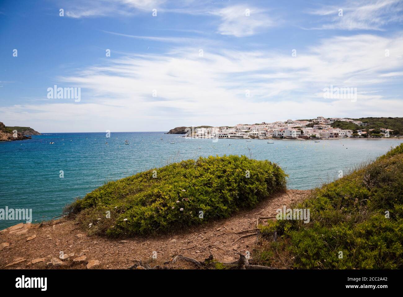 Spanien, Menorca, Es Grau Bucht mit Fischerdorf im Hintergrund Stockfoto