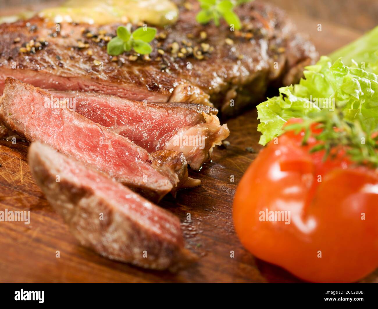 Gegrillte Rib-Eye Steak mit Kräutersauce auf Holz Stockfoto