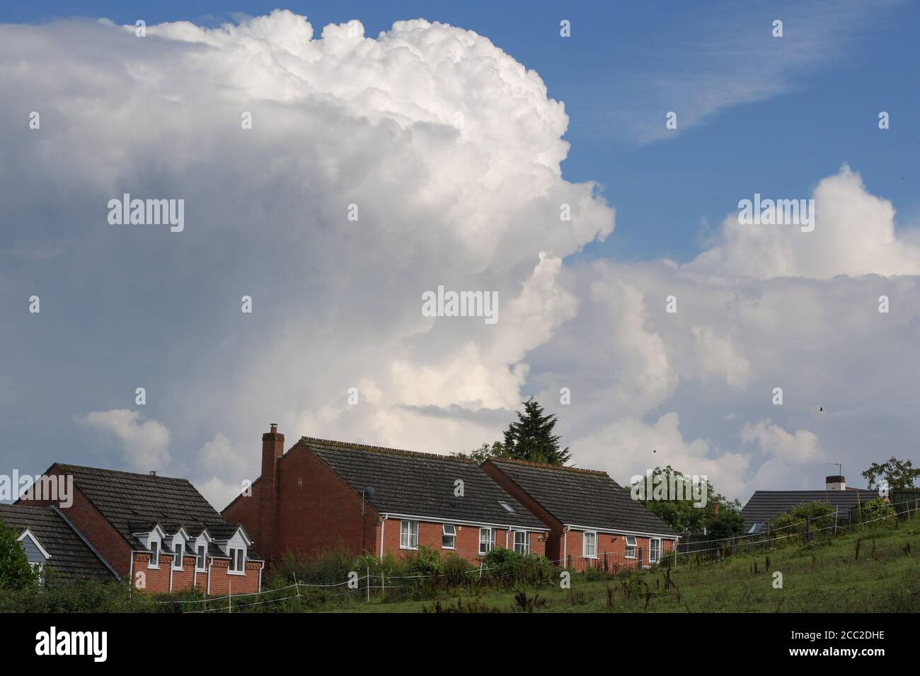 Romsley, Worcestershire, 17. August 2020. Am Montagnachmittag ragen dramatische Wolken über den Häusern in Romsley, Worcestershire, während sich während des heißen Wetters Donner und Blitze weiter formten. Sintflutartige Regenfälle haben die Region getroffen, dürften sich aber in der kommenden Woche beruhigen. Kredit: Sam Holiday/Alamy Live Nachrichten Stockfoto