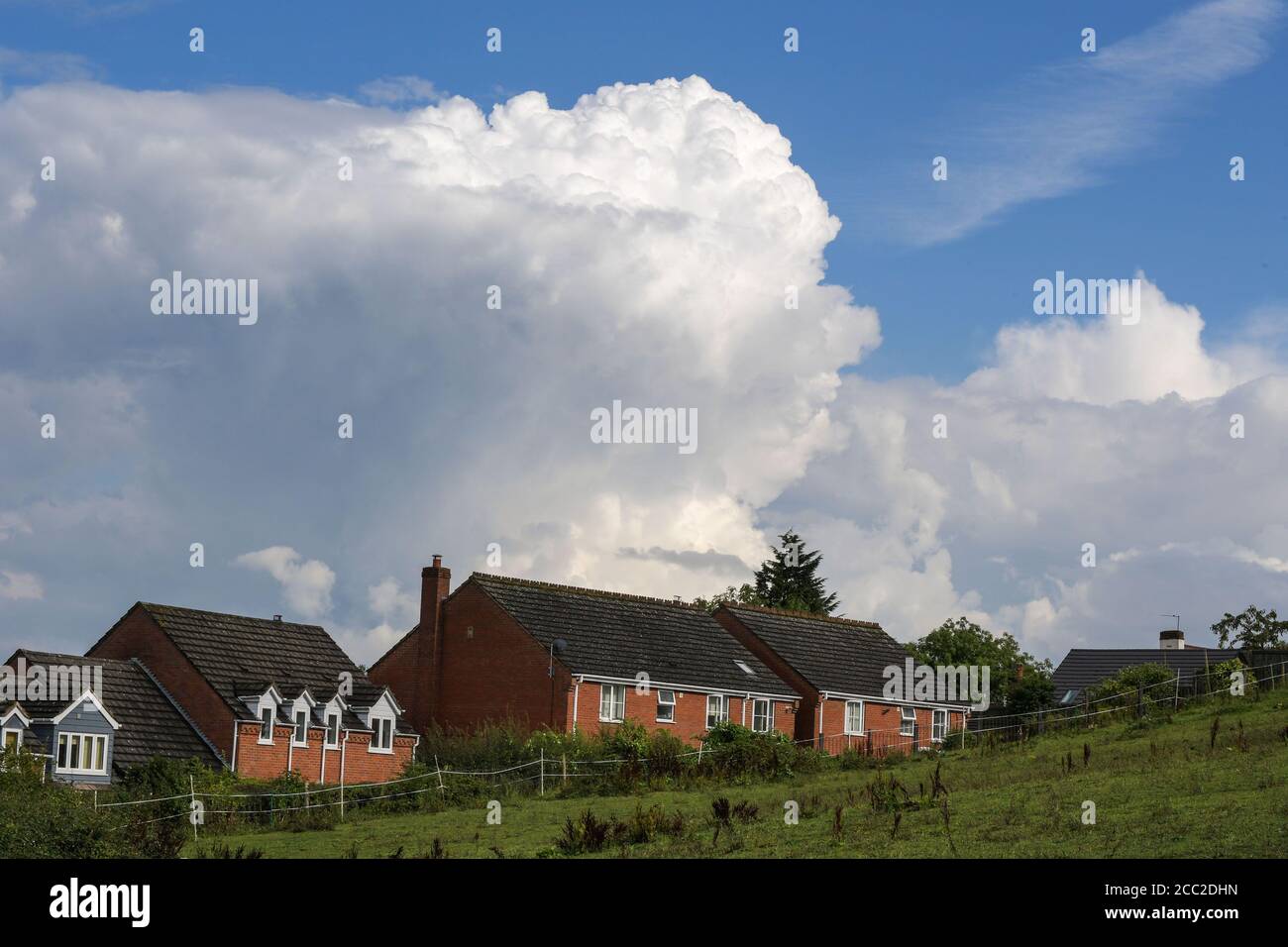 Romsley, Worcestershire, 17. August 2020. Am Montagnachmittag ragen dramatische Wolken über den Häusern in Romsley, Worcestershire, während sich während des heißen Wetters Donner und Blitze weiter formten. Sintflutartige Regenfälle haben die Region getroffen, dürften sich aber in der kommenden Woche beruhigen. Kredit: Sam Holiday/Alamy Live Nachrichten Stockfoto