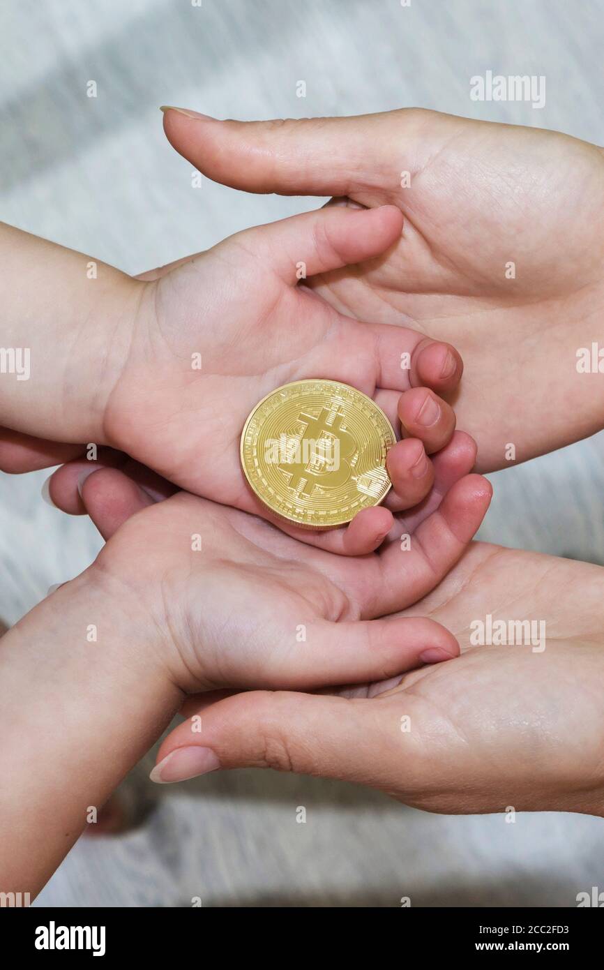 Bitcoin-Konzept. Kinder teilen sich Bitcoin. Kinderhand und Bitcoin. Stockfoto