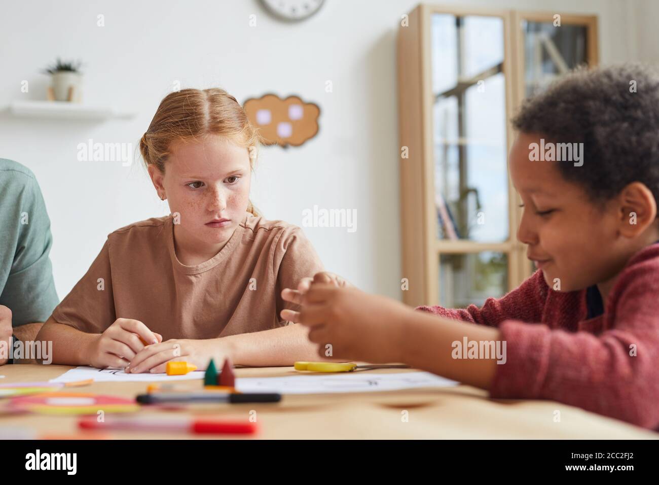 Portrait von Sommersprossen rothaarige Mädchen Blick auf Freund beim Zeichnen von Bildern zusammen während der Kunstklasse in der Schule, kopieren Raum Stockfoto