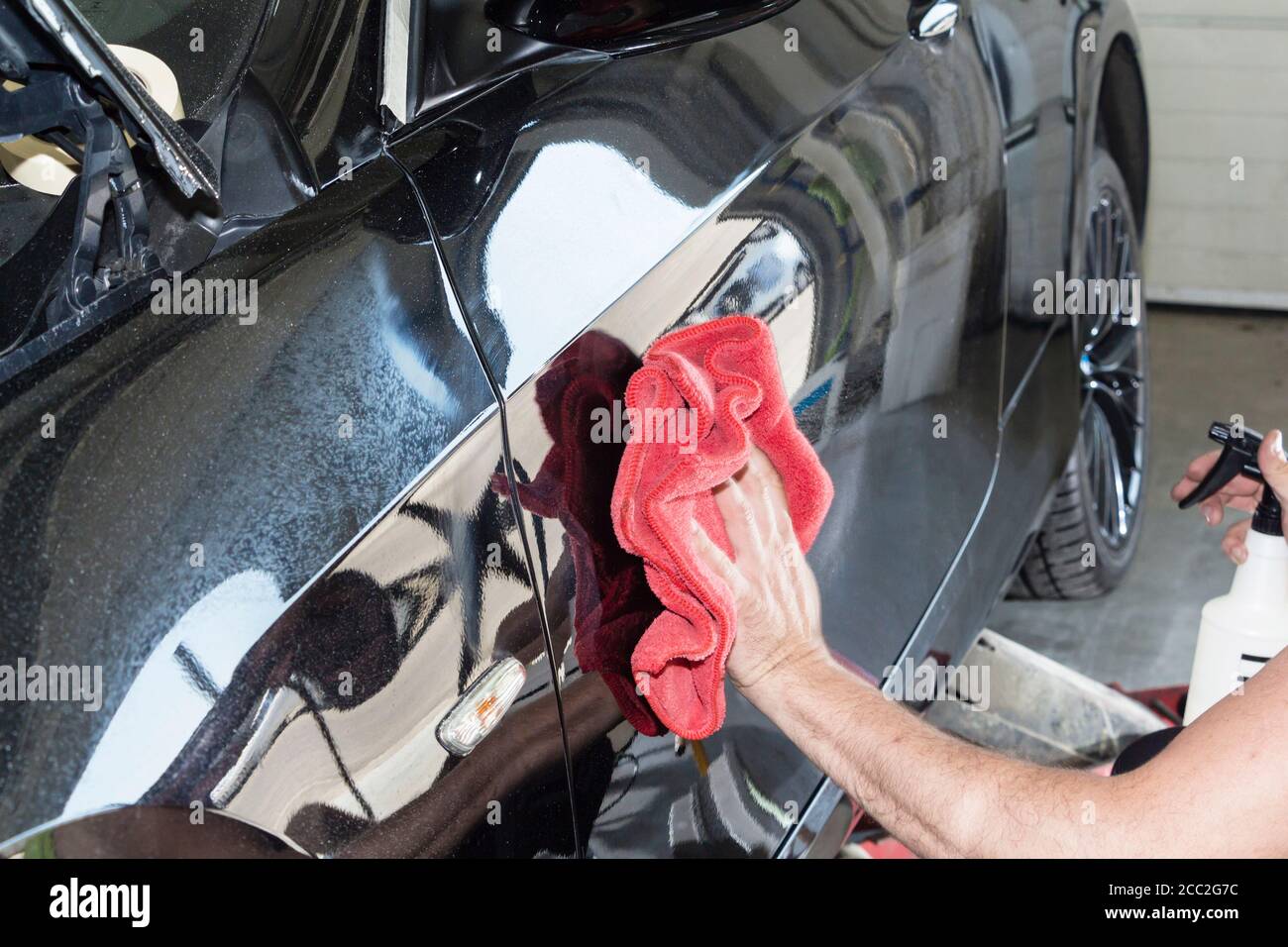 Ein Mann Reinigung Auto mit Mikrofaser Tuch, Auto Detaillierung oder Valeting Konzept. Stockfoto