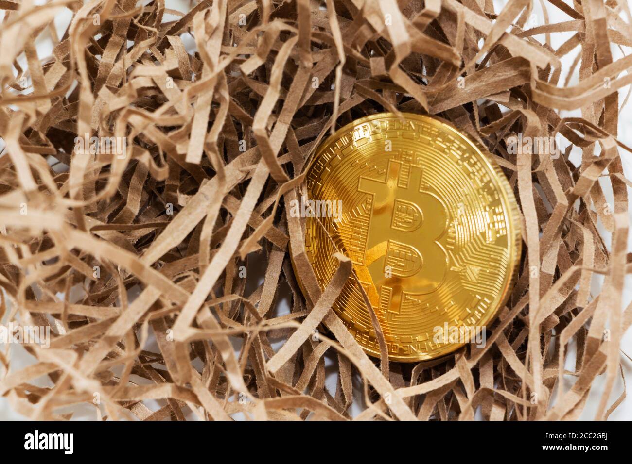 Goldene Bitcoin im Hintergrund des robusten Papiers. Geschäftskonzept. Bitcoin-Absturz. Stockfoto