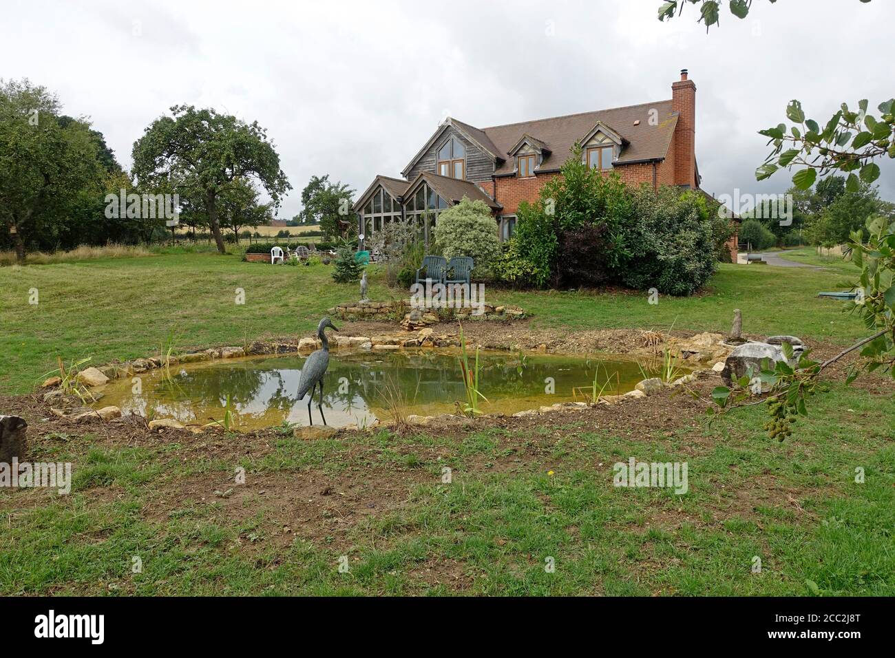 Vor kurzem abgeschlossen großen Gartenteich mit ersten Pflanzung von Teichpflanzen und umgeben von Cotswold Steine, Colemans Hill Farm, Mickleton, Großbritannien Stockfoto