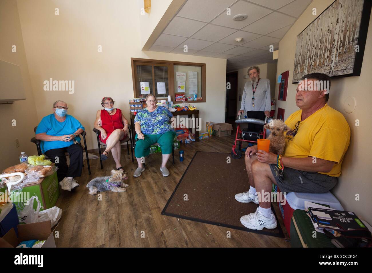 Cedar Rapids, Iowa, USA. August 2020. 16. Aug. 2020: Bewohner der Cedar Village Senior Residences versammeln sich in der Lobby ihres Wohnhauses. Der Manager hat sie fast aufgegeben und keine Hilfe angeboten. Sie haben keinen Strom von heißem Wasser. Mehrere Bewohner stecken oben fest, da sie behindert sind und der Aufzug nicht funktioniert. Sie bitten um Hilfe. Cedar Rapids und viele der umliegenden Grafschaften wurden am 10. August von einem Derecho getroffen. Fast eine Woche später, und viele Menschen sind immer noch ohne Strom, einige schlafen in Zelten und Plätze ohne Klimaanlage und Warmwasser, in der Hoffnung t Stockfoto