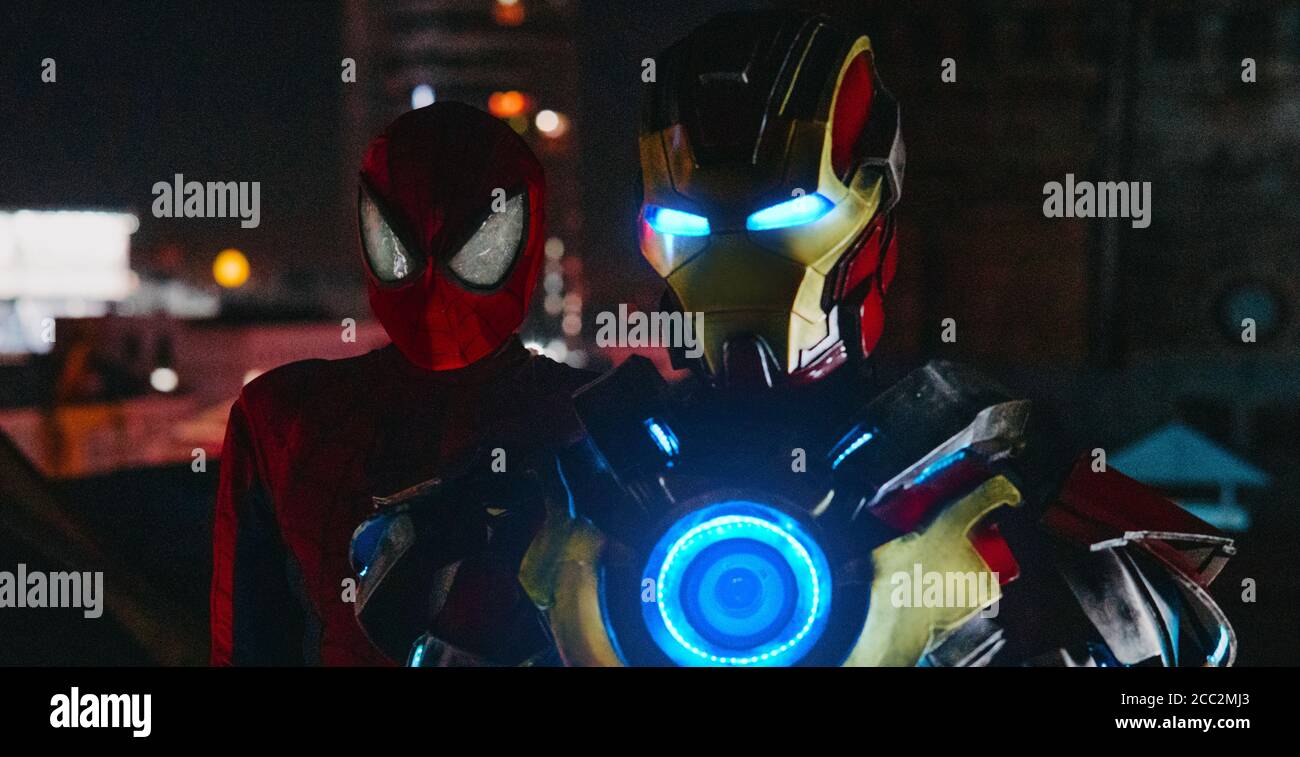 Zwei Cosplayer stehen in Bildern von Spider-man und Iron man bei Nacht zusammen. Stockfoto