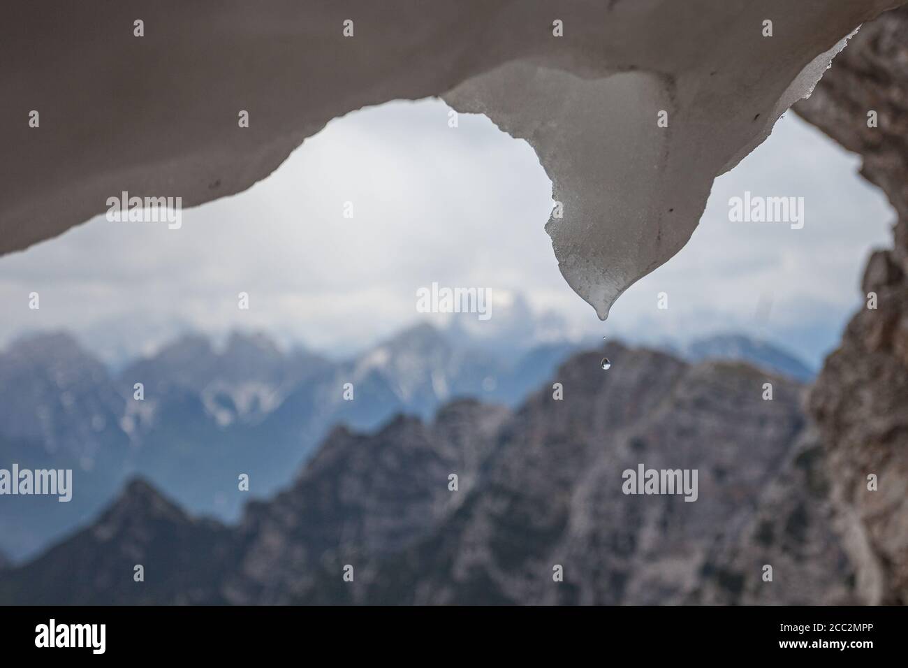 Wassertropfen fällt aus schmelzendem Schnee und verschwommener Dolomitenpanorama Hintergrund, Dolomiten, Italien Stockfoto