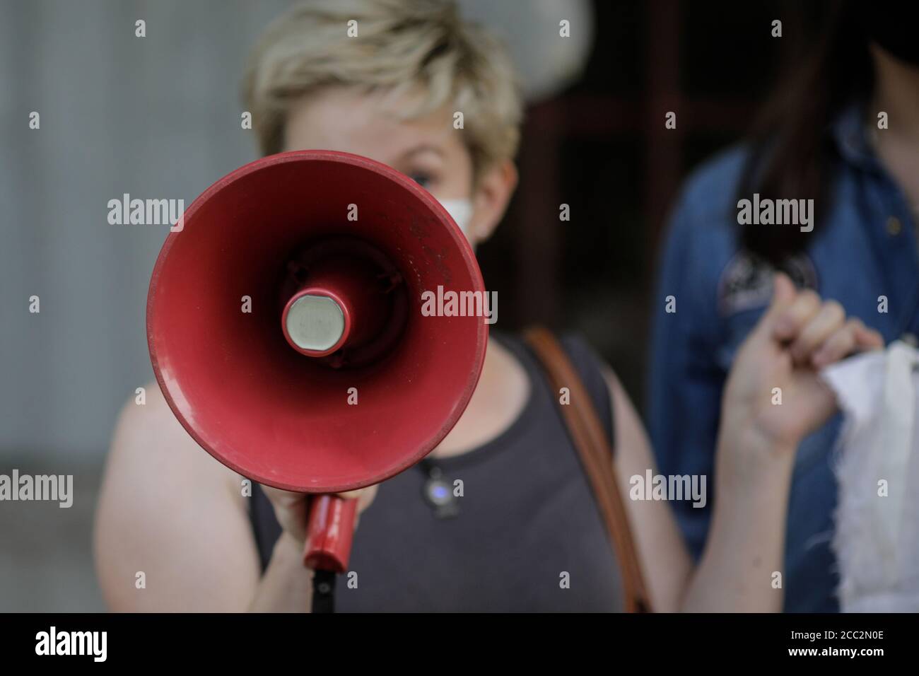Details mit einem Bullhorn, das von einer Frau während einer politischen/sozialen Kundgebung gehalten wird. Stockfoto