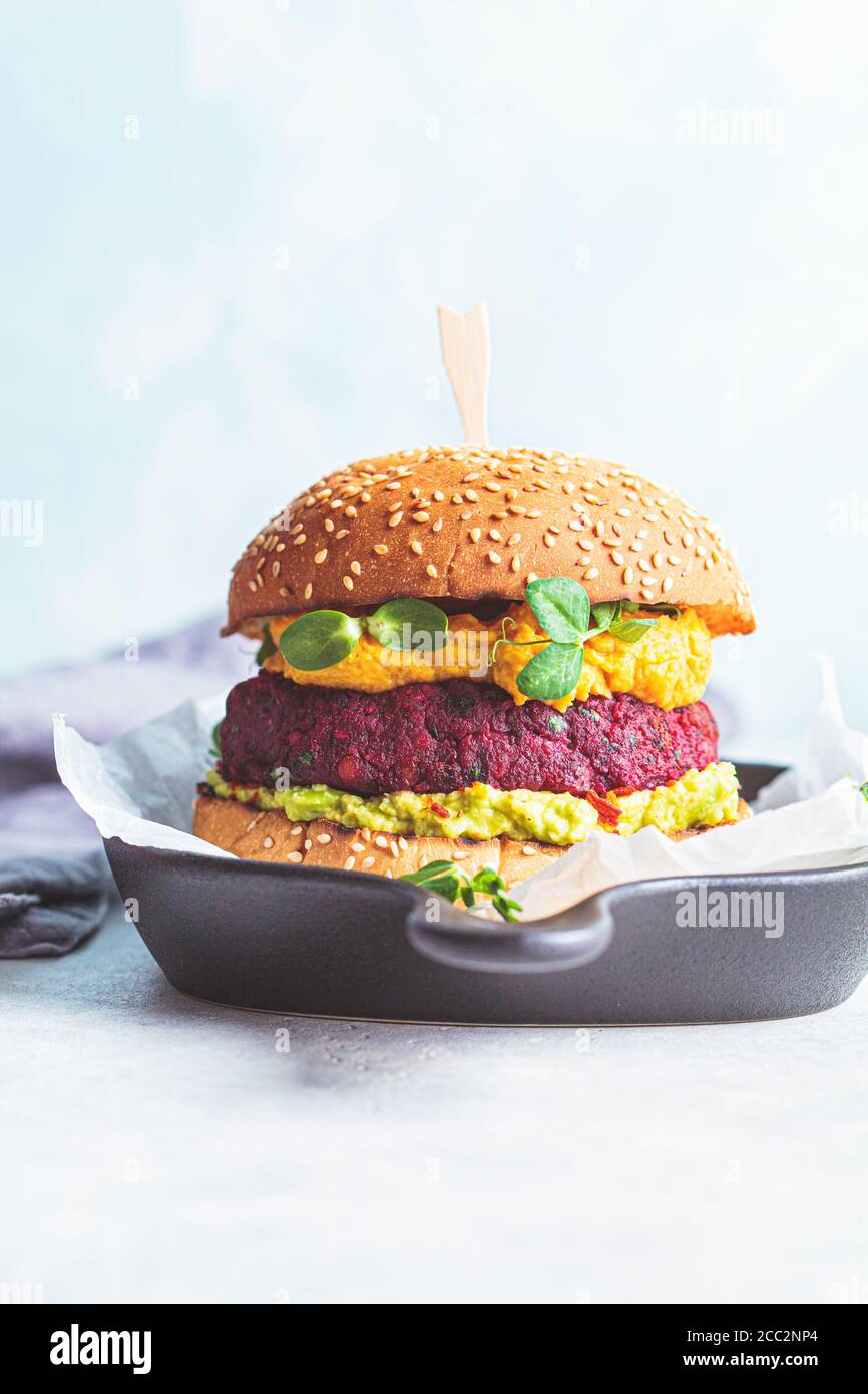 Veganer Burger mit Rote Beete, Süßkartoffelsauce und Guacamole. Stockfoto