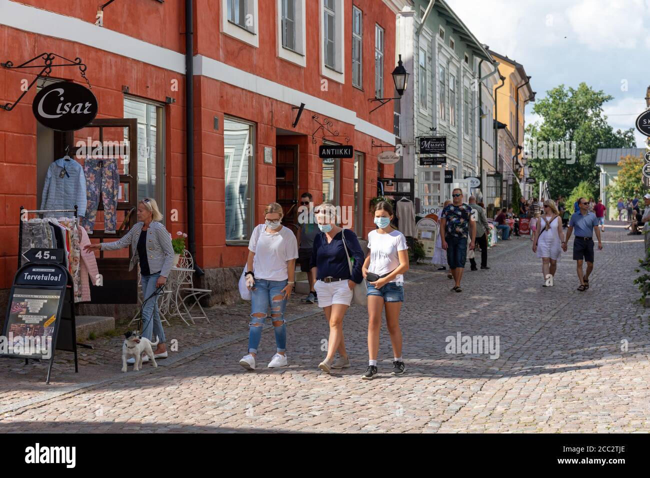 Gesichtsmaske tragen Touristen schlendern auf gepflasterten Straße der Altstadt in Porvoo, Finnland während COVID-19 Pandemie Stockfoto