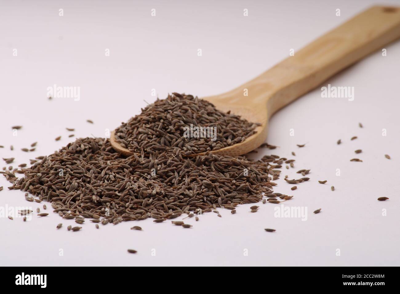 Holzlöffel voll Kreuzkümmel Samen isoliert über dem weißen Hintergrund. Stockfoto