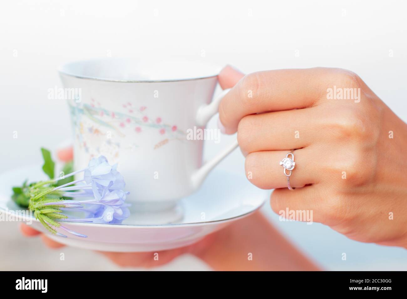 Keramik Tasse Tee mit Blumen in den Damen gepflegte Hände mit Maniküre. Stockfoto