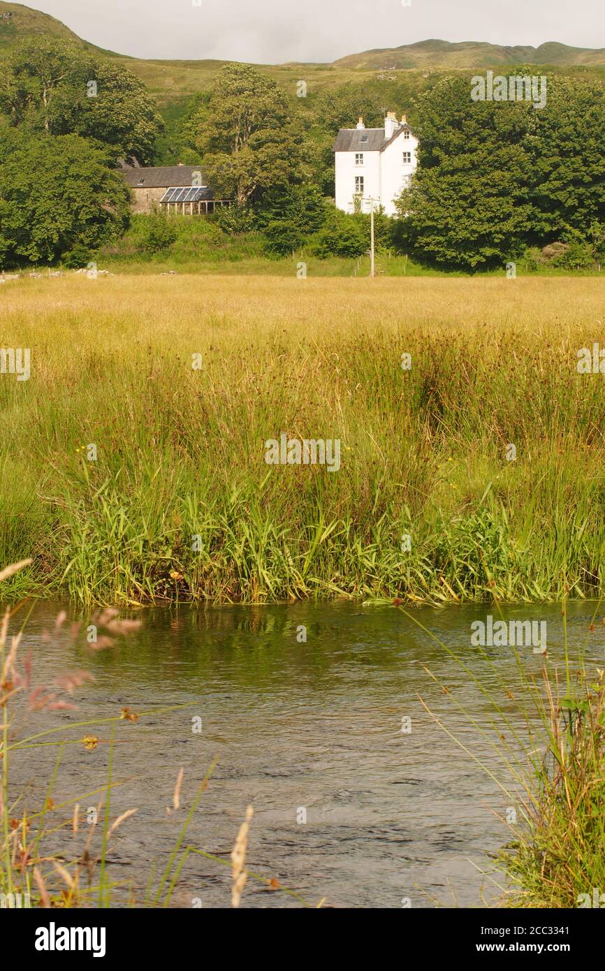 Ein Blick auf das Museum in Kilmartin von der anderen Seite des Kilmartin Burn im Vordergrund und das Feld dahinter, Argyll, Schottland Stockfoto