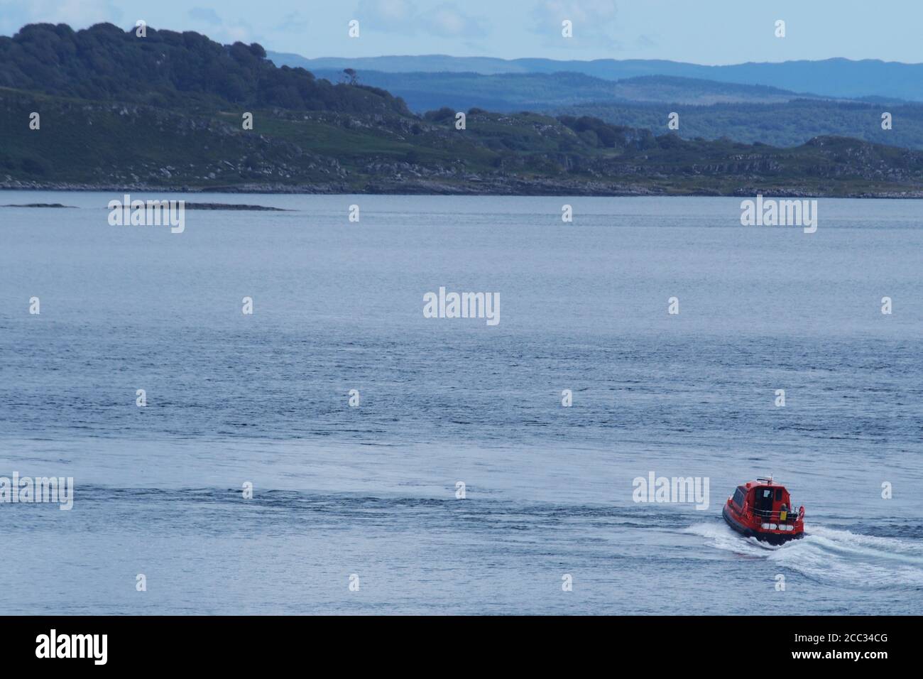 Ein kleines, tourend, Motorboot, das Passagiere auf einer Vergnügungskreuzfahrt um die Inseln im Sound of Jura an einem ruhigen Sommertag befördert Stockfoto