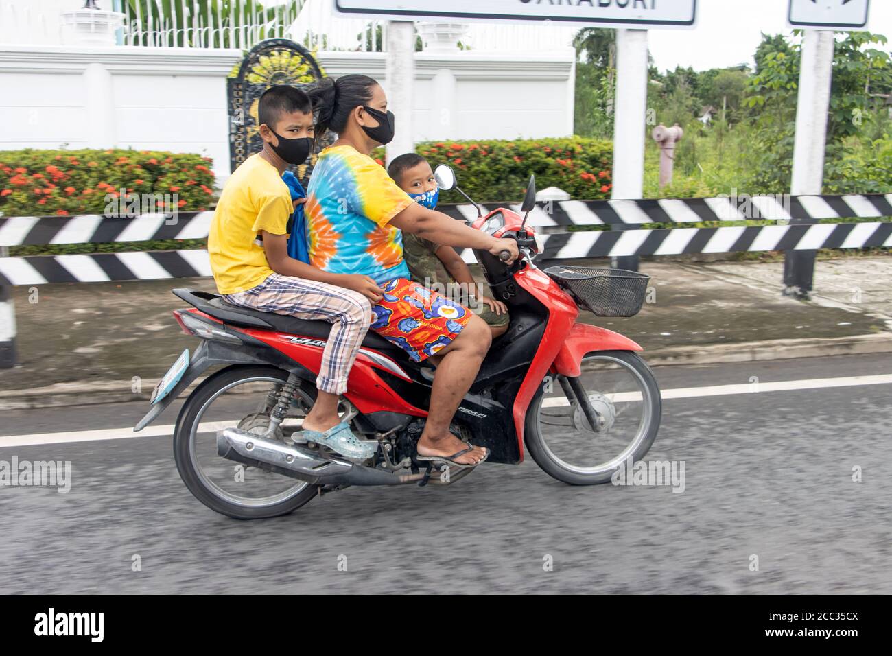 NAKHON NAYOK, THAILAND, JULI 04 2020, EINE thailändische Familie fährt zusammen auf einem Motorrad. Asiatische Frau reitet ein Motorrad mit zwei Jungen. Stockfoto