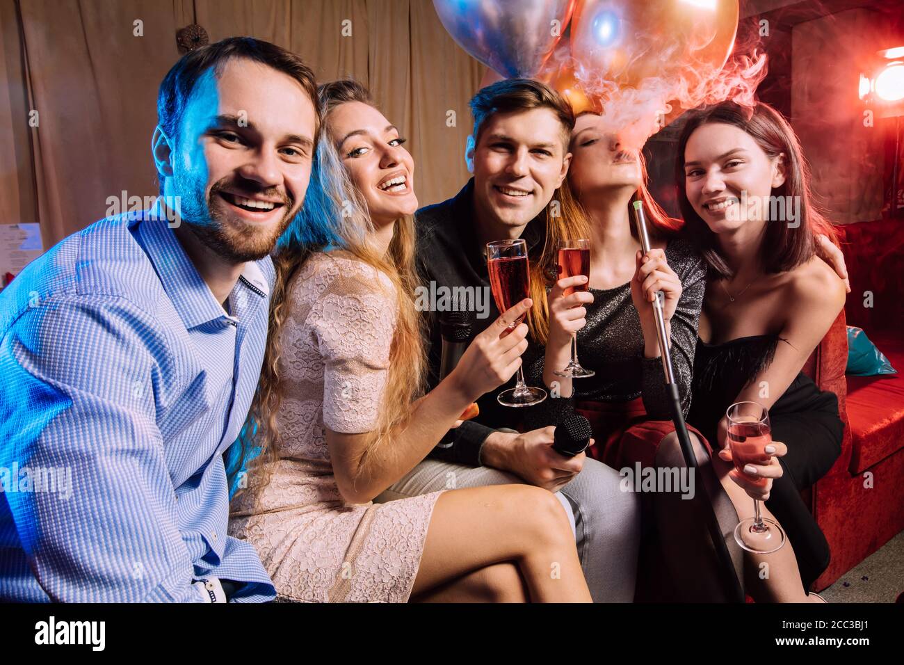 Junge Leute feiern Geburtstag in Karaoke-Bar, singen und rauchen Shisha. Freizeit, glücklich positive Zeitvertreib Stockfoto