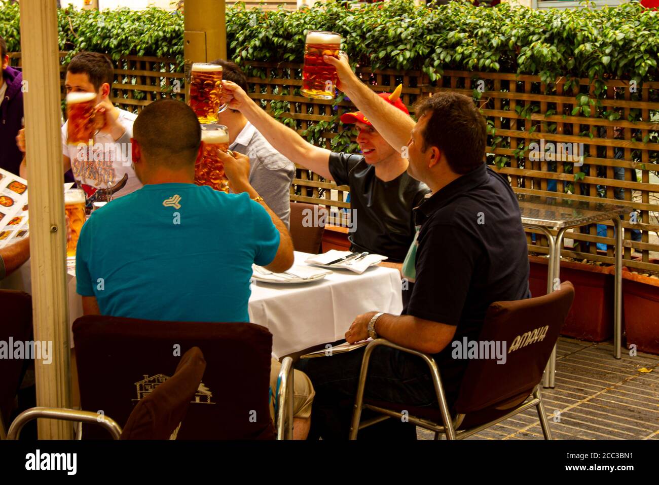 Barcelona, Spanien 05/01/2010: Eine Gruppe von Männern feiern eine Veranstaltung, während sie in einem Restaurant sitzen. Sie tragen legere Kleidung und alle heben ihr Bier Stockfoto