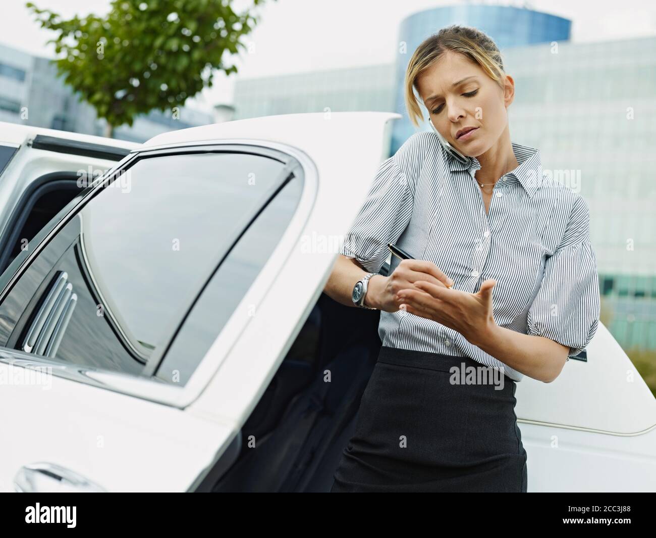 Geschäftsfrau Nimmt Notizen Auf Handfläche Während Telefonanruf Stockfoto