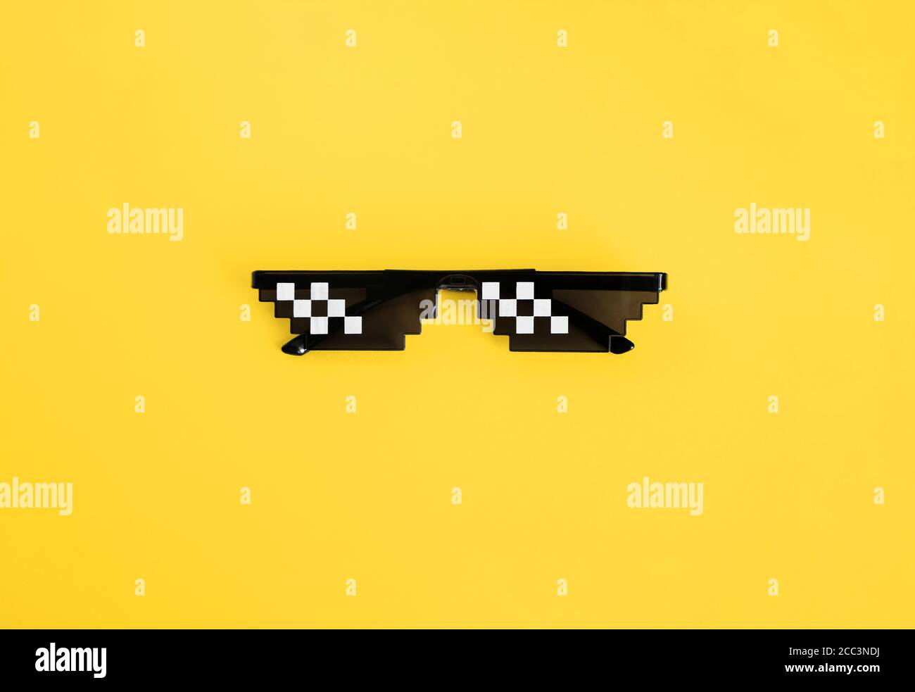 Lustige verpixelte Boss Sonnenbrille auf gelbem Hintergrund. Gangster, schwarz Strolch Leben Meme Brille . Pixel-8-Bit-Stil Stockfoto