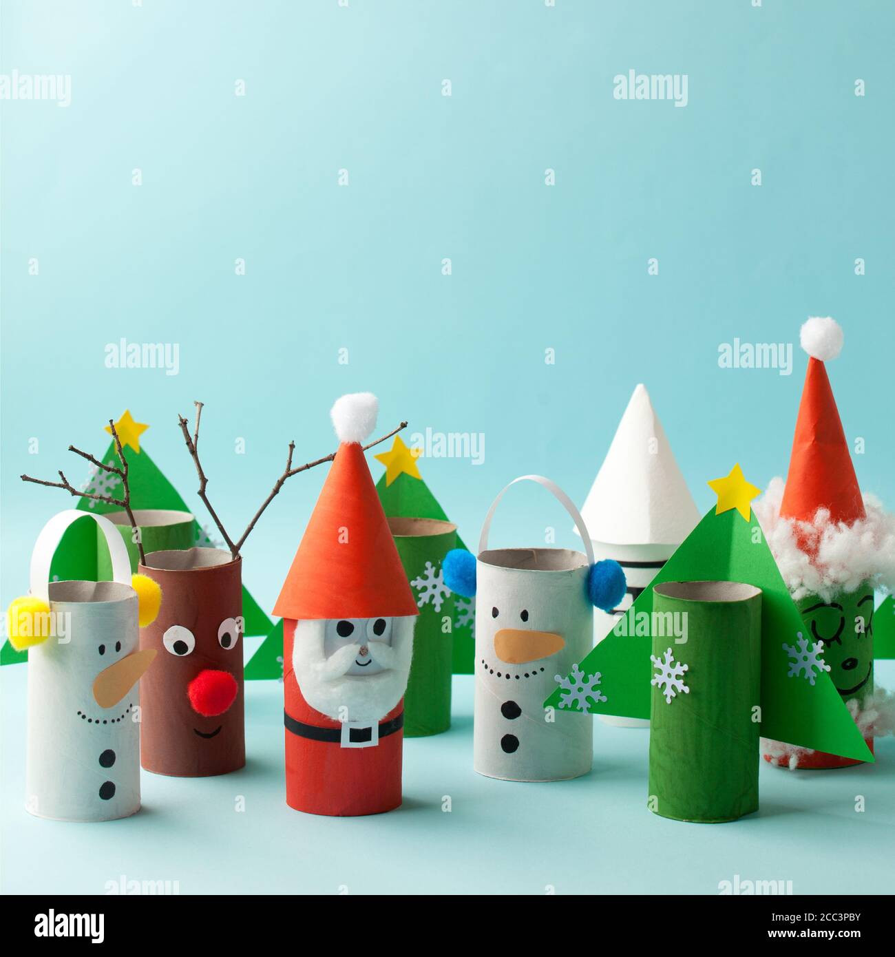 Papierspielzeug Weihnachtsmann, Schneemann, Grinch für Weihnachtsfeier. Einfache Basteln für Kinder auf blauem Hintergrund, kopieren Raum, sterben kreative Idee von Toilettenpapierrolle, recyceln Stockfotografie