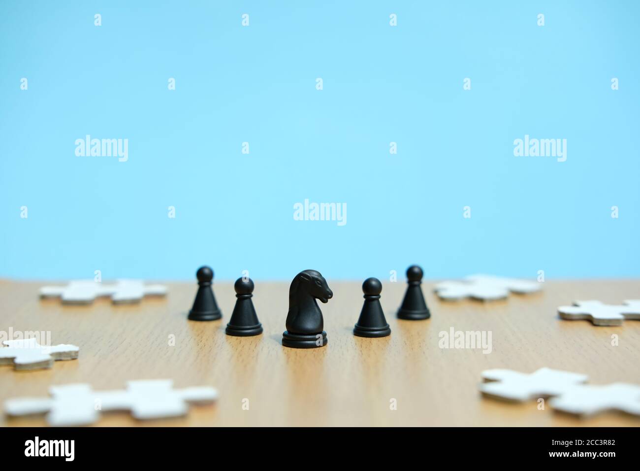 Konzeptionelles Foto der Geschäftsstrategie - eine Linie des Pferdes Schachfiguren in der Mitte einer Armee und Puzzle Puzzles Stockfoto