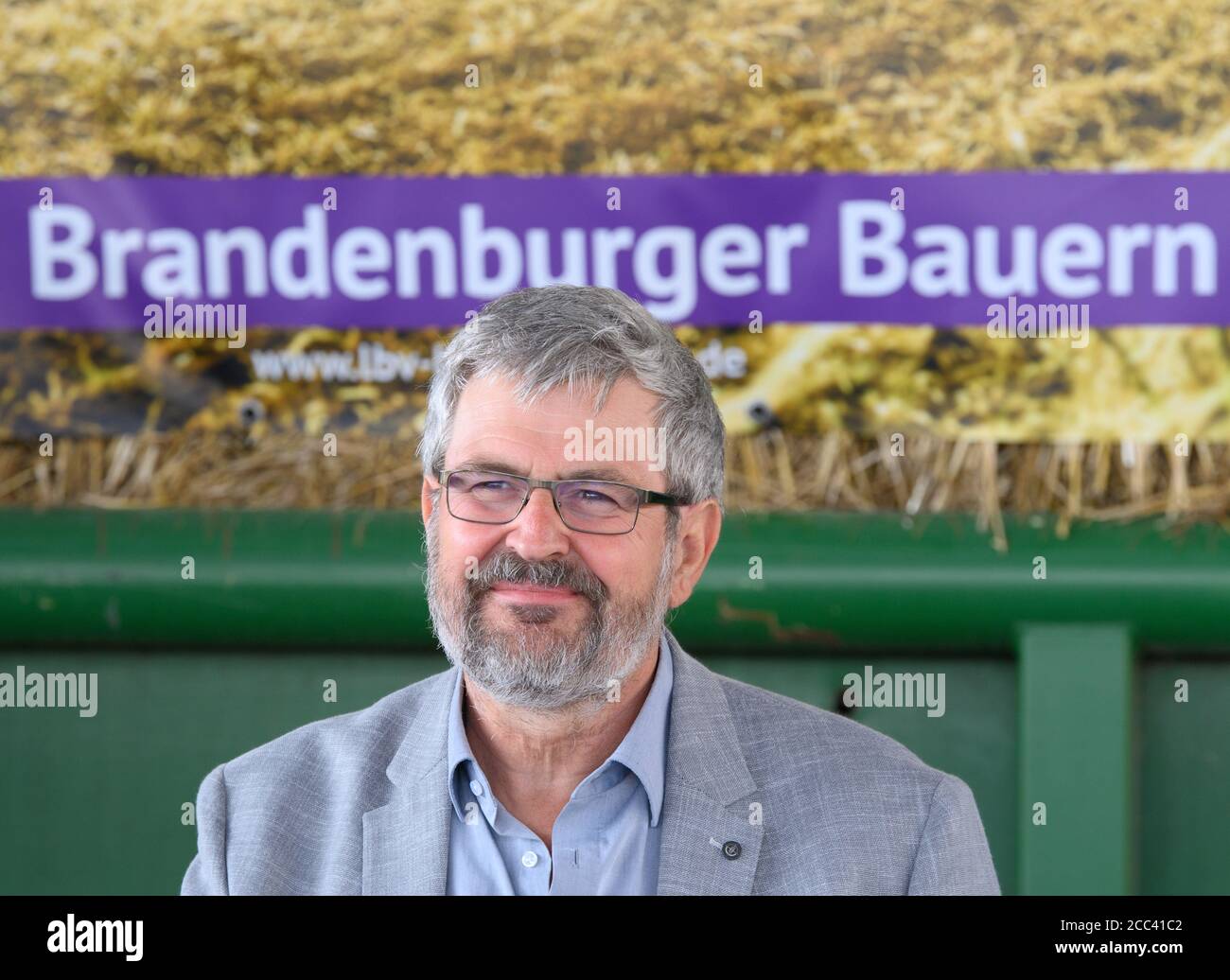 18. August 2020, Brandenburg, Niedergörsdorf/ OT Oehna: Axel Vogel (Bündnis 90/die Grünen), Brandenburgs Minister für Landwirtschaft, Umwelt und Klimaschutz, lächelt bei einer Pressekonferenz zur Erntebilanz 2020 und sitzt vor einem Plakat mit der Aufschrift "Brandenburgische Bauern". Foto: Soeren Sache/dpa-Zentralbild/ZB Stockfoto