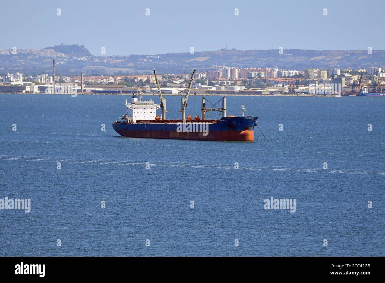 Lissabon, Portugal. August 2020. Ein Frachter, Frachtschiff, Schiff fährt auf dem Rio Tejo in Richtung Atlantik. Eindrücke aus Lissabon während der Coronavirus-Pandemie am 16. August 2020. Quelle: dpa/Alamy Live News Stockfoto