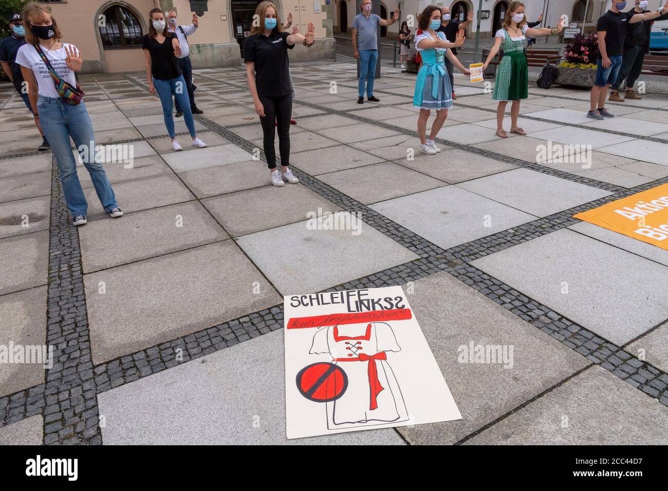18. August 2020, Bayern, Passau: Ein Schild mit der Aufschrift 'Schleife links? - kein Freifahrtschein' liegt auf dem Boden vor dem Rathaus während einer Kundgebung von Anti-Donaulied-Aktivisten, um die Online-Petition zu schließen. Die Gruppe will sicherstellen, dass das Donaulied nicht mehr in Passauer Bierzelten gespielt wird und setzt sich bei Volksfesten gegen Sexismus ein. Foto: Peter Kneffel/dpa Stockfoto