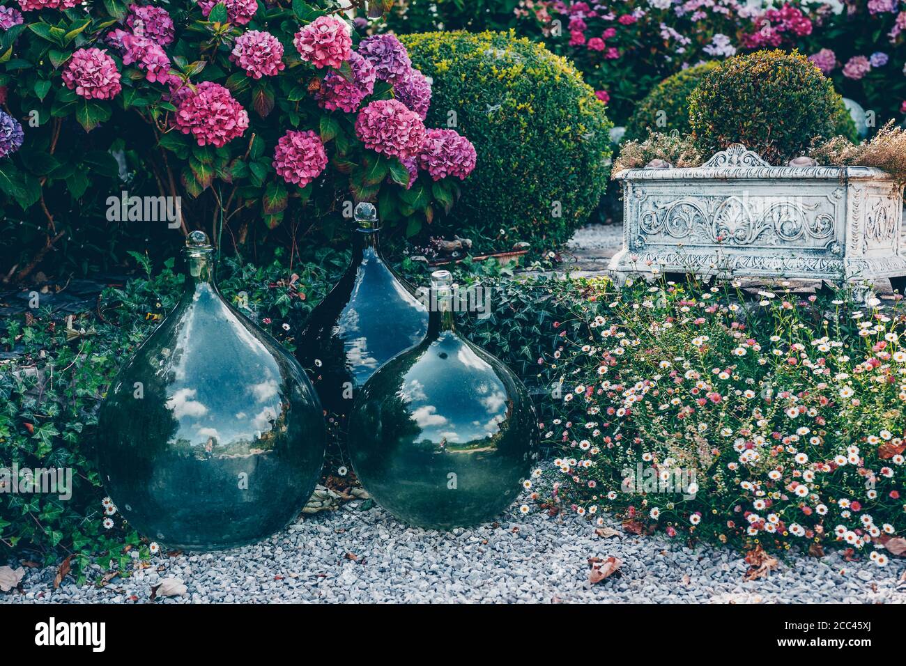 Grüne Flasche Dame Jeanne. Dekoratives Objekt im Garten. Hochwertige Fotos Stockfoto