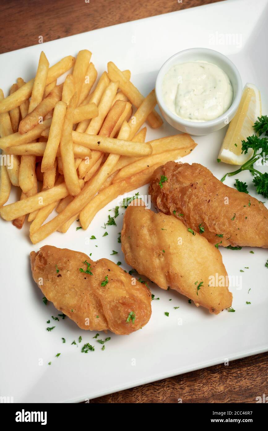 traditionelle britische Fish & Chips Mahlzeit auf Holztisch Stockfoto