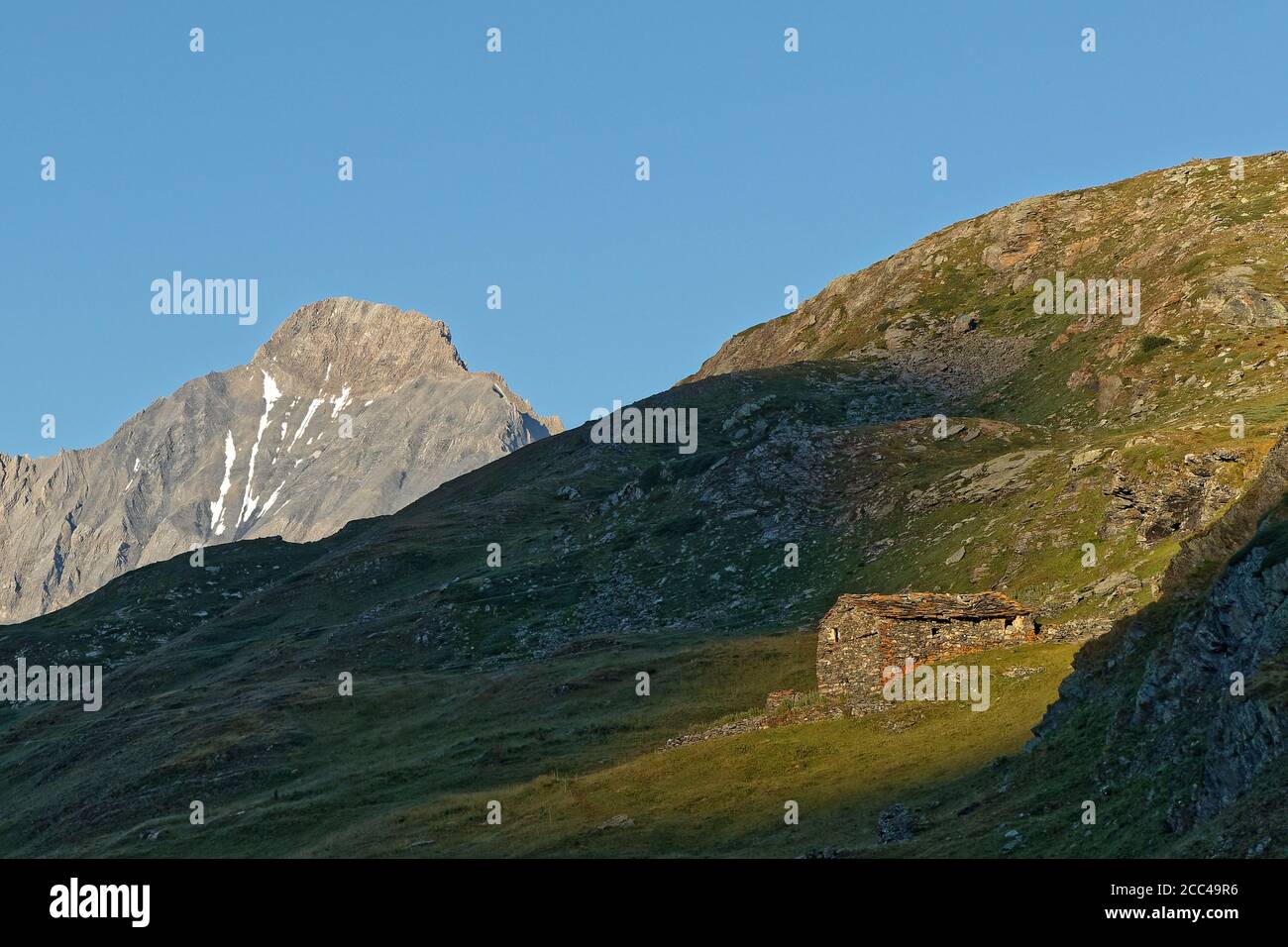 Alte Steinhütte an den grünen Hängen der französischen Alpen Im Morgengrauen Stockfoto