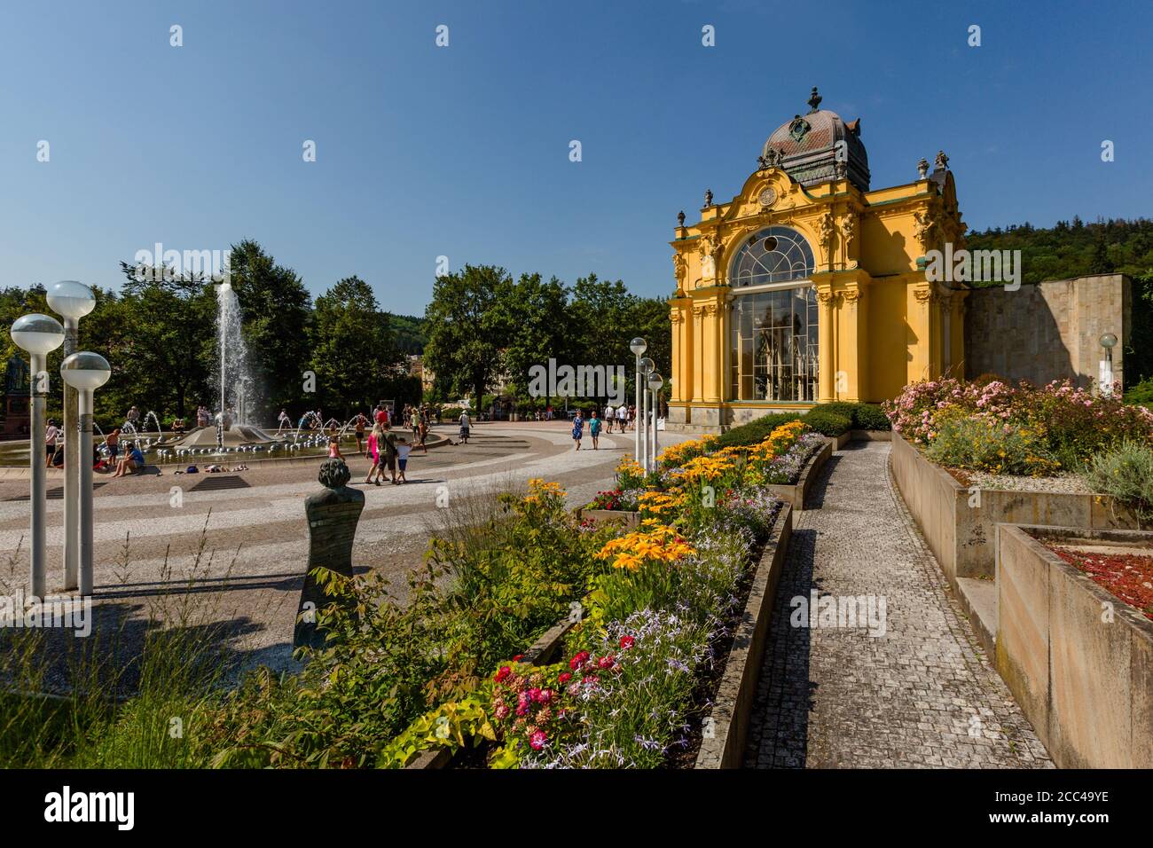 Marianske Lazne / Tschechische Republik - August 11 2020: Blick auf die Maxim Gorki Kolonnade mit gelbem Gebäude, Brunnen, grünen Bäumen, Blumen. Stockfoto