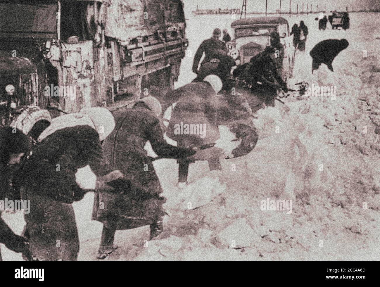 Die Nazis nutzen die Zwangsarbeit sowjetischer Zivilisten (Frauen und alte Menschen), um Straßen aus dem Schnee zu räumen, um einen Armeekonvoi zu durchfahren. Stockfoto