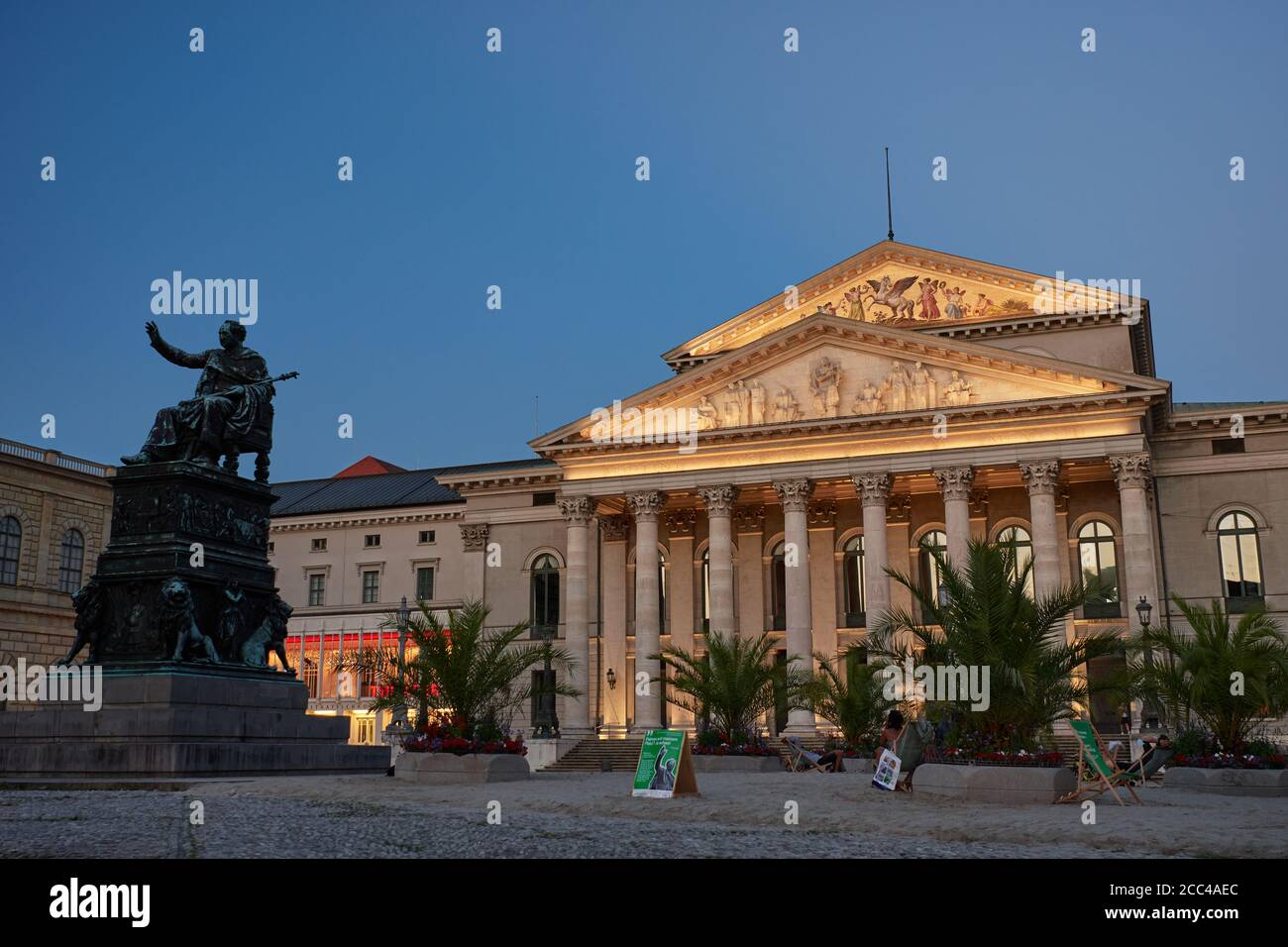 München, Deutschland - 9. August 2020: Ein temporärer Palmenstrand wurde vor das Nationaltheater in München gebracht, um "Sommer in der Stadt" zu feiern Stockfoto
