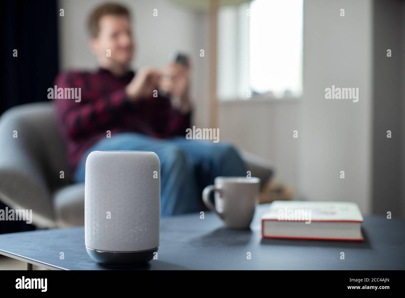 Man Streamen Musik Oder Podcast Auf Smart Speaker Von Mobil Telefon Zu Hause Stockfoto