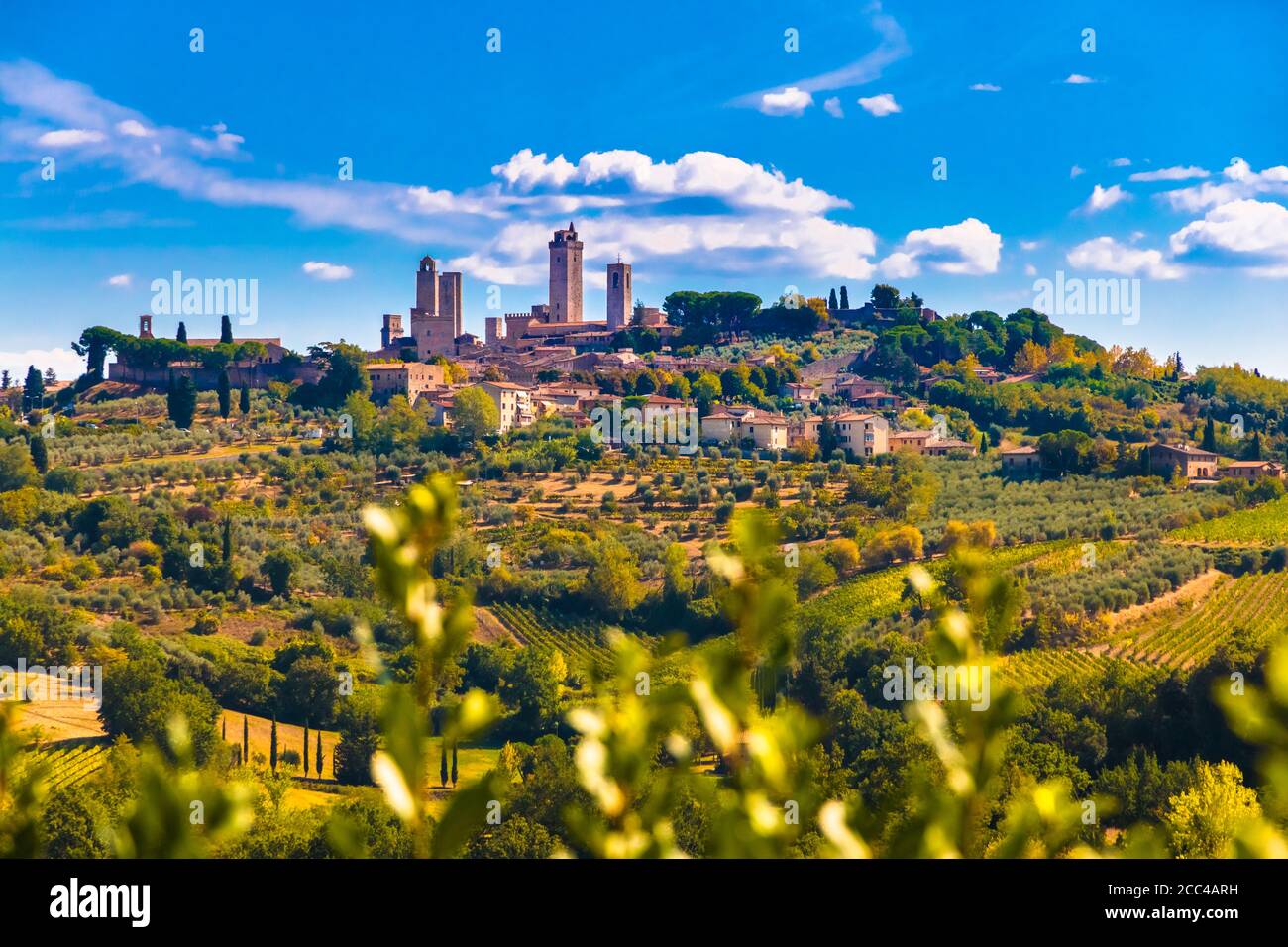 Atemberaubender Panoramablick auf die berühmte mittelalterliche Hügelstadt San Gimignano mit einem Blick auf die Türme durchdringen die weißen Wolken. Es ist umgeben von... Stockfoto