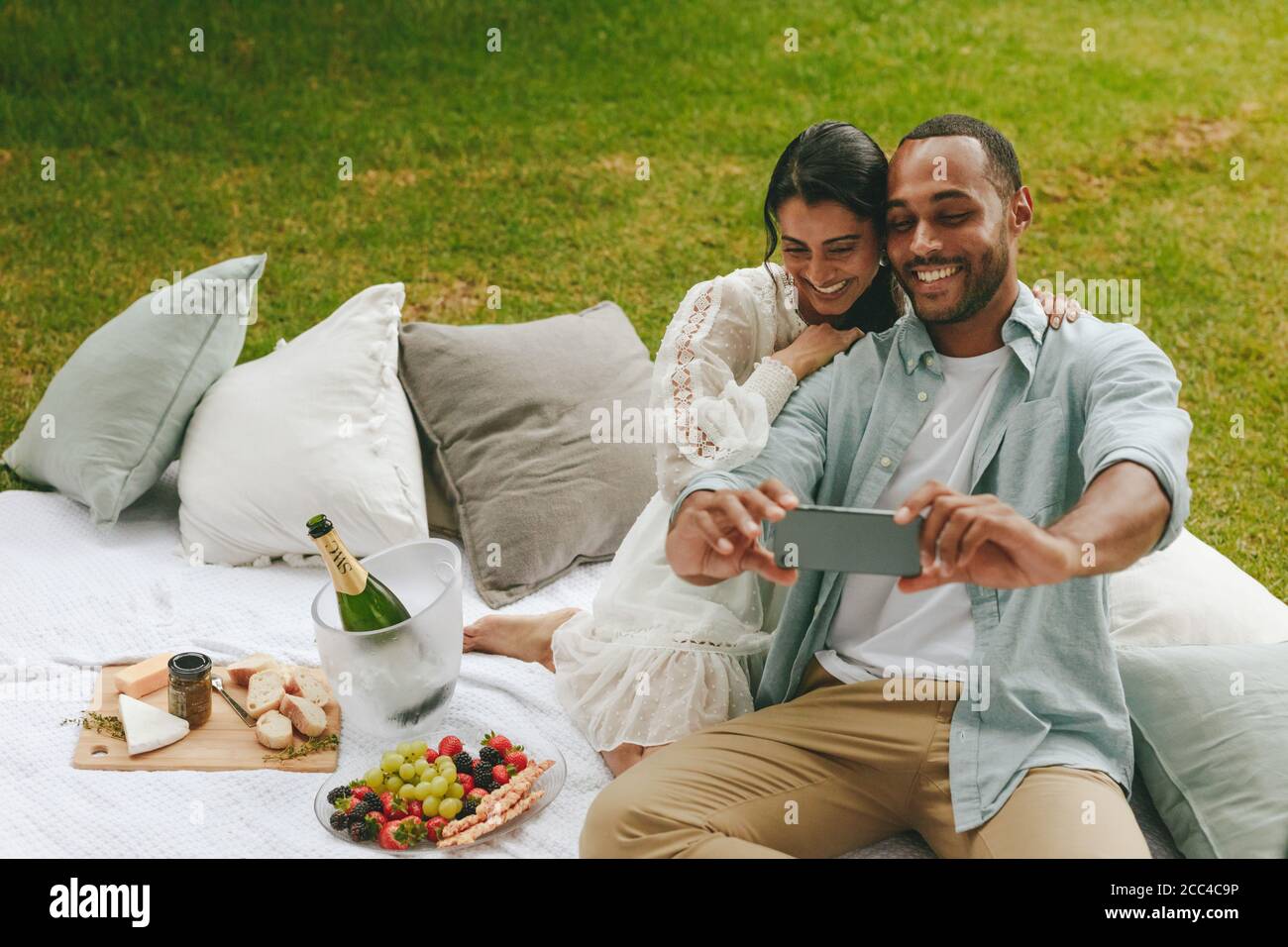 Liebevolles junges Paar, das Selfie im Park nimmt. Schönes Paar auf Picknick unter Selbstporträt im Park. Stockfoto